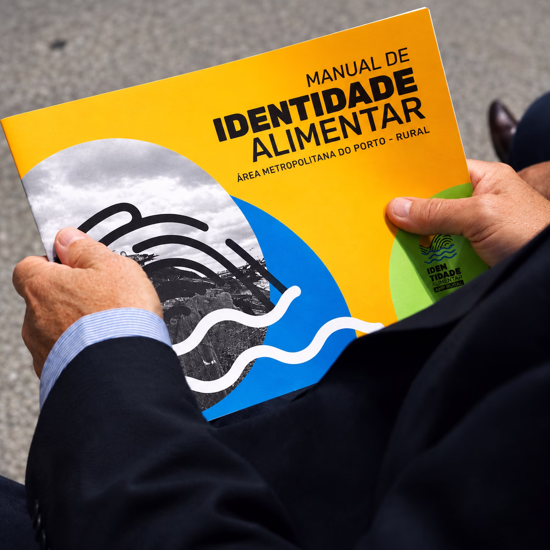 Hands holding the printed Identidade Alimentar brand manual